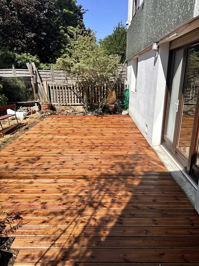 Terrasse en pin fraîchement posée au pied d’un immeuble
